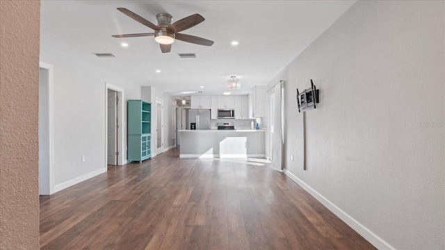 unfurnished living room featuring dark hardwood / wood-style flooring and ceiling fan