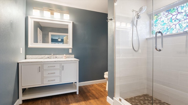 bathroom featuring hardwood / wood-style floors, vanity, a shower with door, and toilet