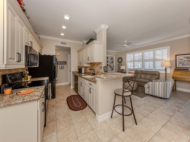 kitchen with backsplash, light stone countertops, ceiling fan, and black appliances