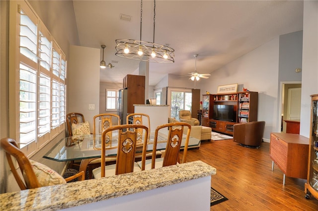 dining area featuring hardwood / wood-style floors, ceiling fan, and vaulted ceiling