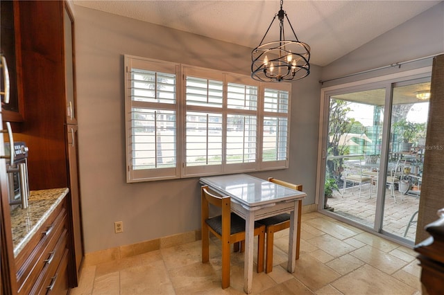 dining area with a chandelier and vaulted ceiling