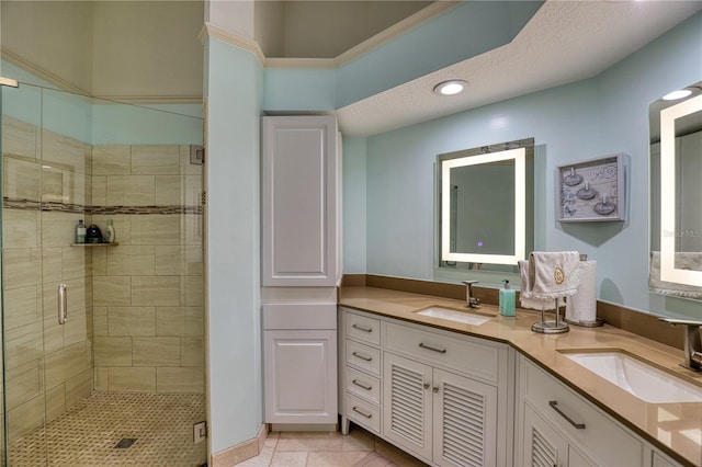 bathroom featuring tile patterned floors, vanity, a shower with shower door, and a textured ceiling