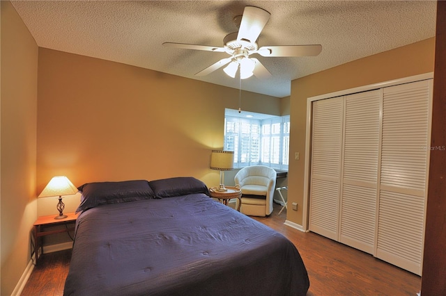 bedroom featuring ceiling fan, dark hardwood / wood-style flooring, a textured ceiling, and a closet