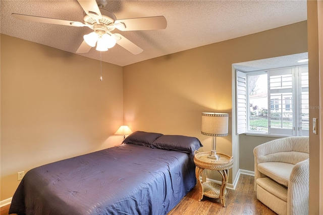 bedroom with wood-type flooring, a textured ceiling, and ceiling fan