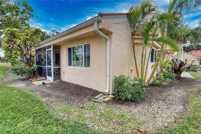 view of property exterior featuring a sunroom