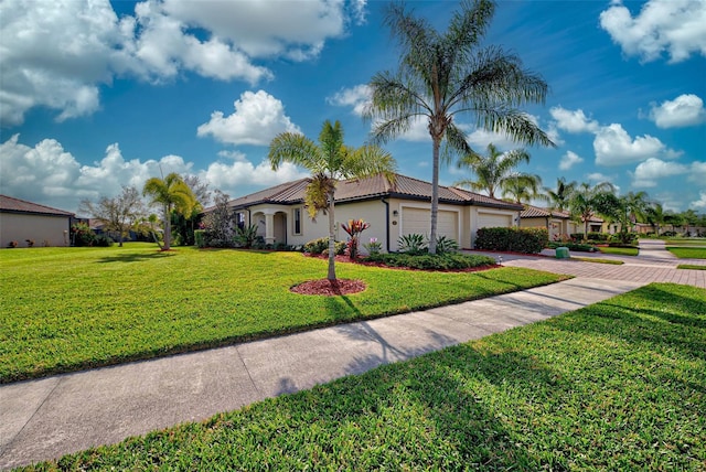 mediterranean / spanish-style house with a garage and a front lawn