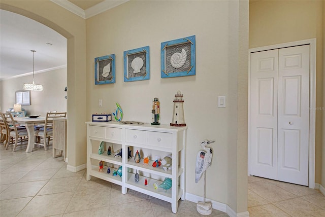 corridor featuring light tile patterned floors and crown molding