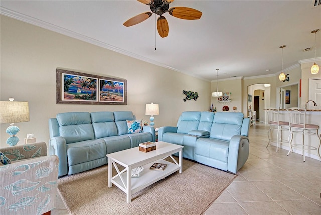 tiled living room featuring ceiling fan and crown molding