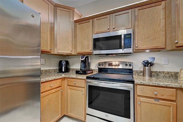 kitchen featuring light stone countertops and stainless steel appliances