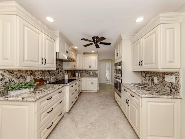 kitchen featuring ceiling fan, black electric cooktop, double oven, light stone counters, and extractor fan