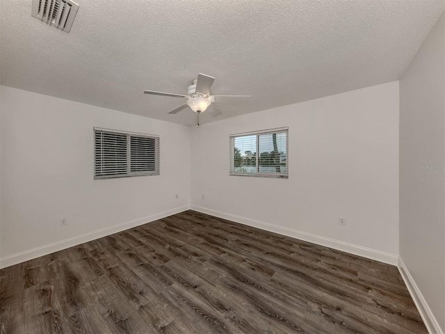 empty room with ceiling fan, dark hardwood / wood-style flooring, and a textured ceiling