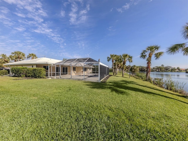 back of house with a lanai, a lawn, and a water view