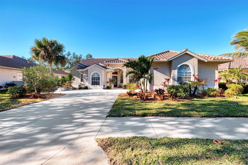 mediterranean / spanish-style home featuring a front yard