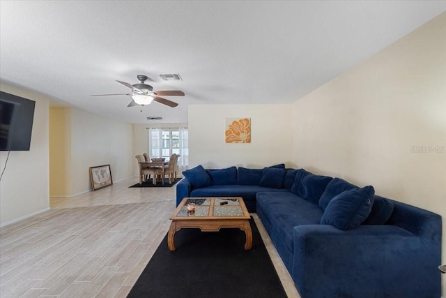 living room featuring ceiling fan and light hardwood / wood-style floors