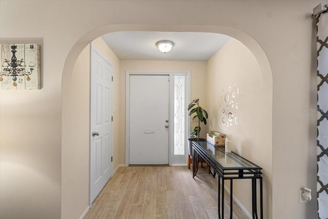 entryway featuring a textured ceiling and light hardwood / wood-style floors