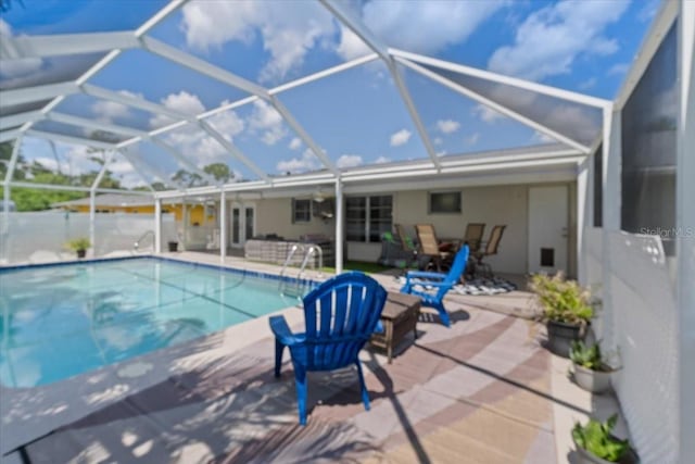 view of swimming pool featuring glass enclosure and a patio