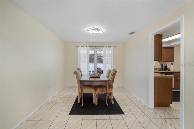 dining room featuring light tile patterned flooring and a textured ceiling