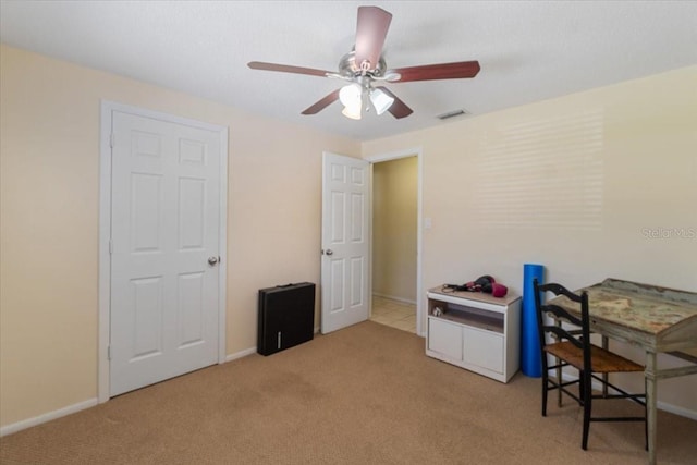 carpeted office space with ceiling fan