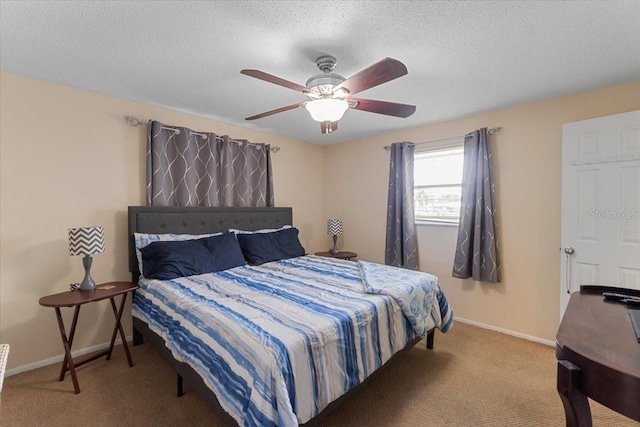 bedroom with ceiling fan, light colored carpet, and a textured ceiling