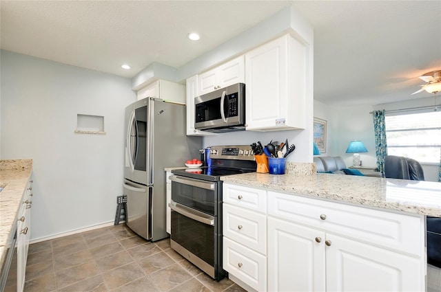 kitchen featuring white cabinets, light stone counters, and appliances with stainless steel finishes