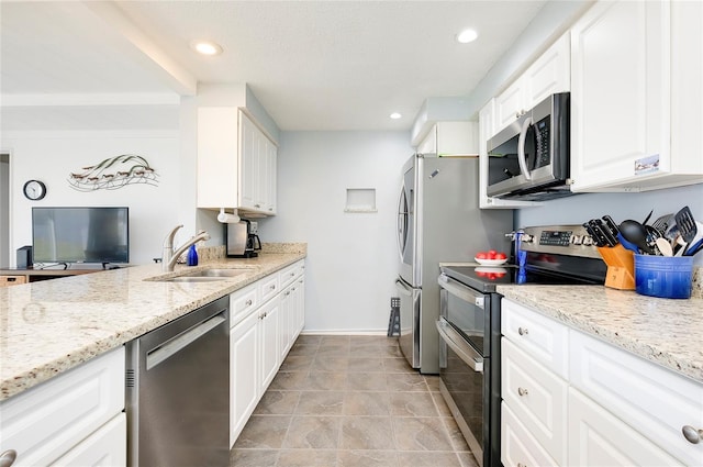 kitchen featuring white cabinets, sink, light stone countertops, and stainless steel appliances