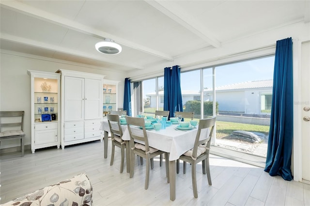 dining space featuring beam ceiling and light hardwood / wood-style flooring