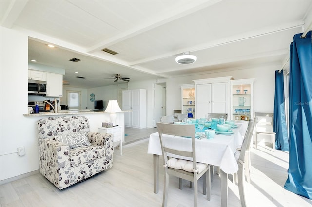 dining room with beamed ceiling, light hardwood / wood-style floors, and ceiling fan