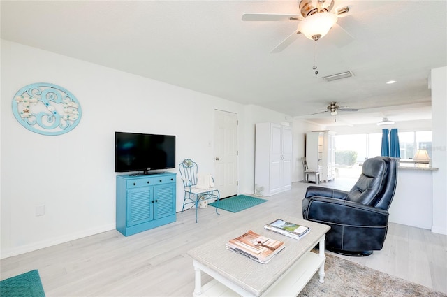 living room featuring ceiling fan and light hardwood / wood-style flooring