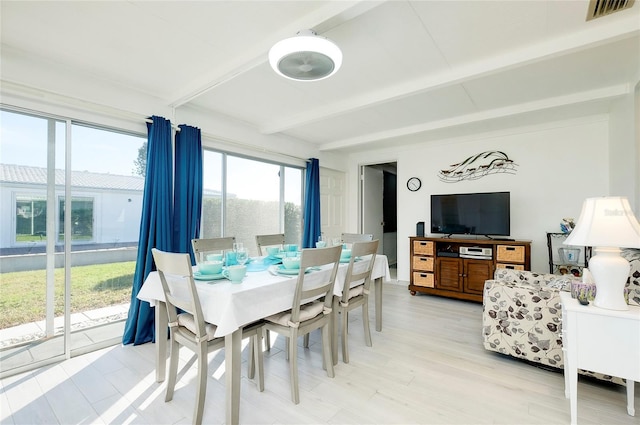 dining area with beamed ceiling and hardwood / wood-style flooring