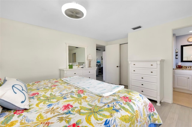 bedroom featuring ensuite bathroom and light hardwood / wood-style floors