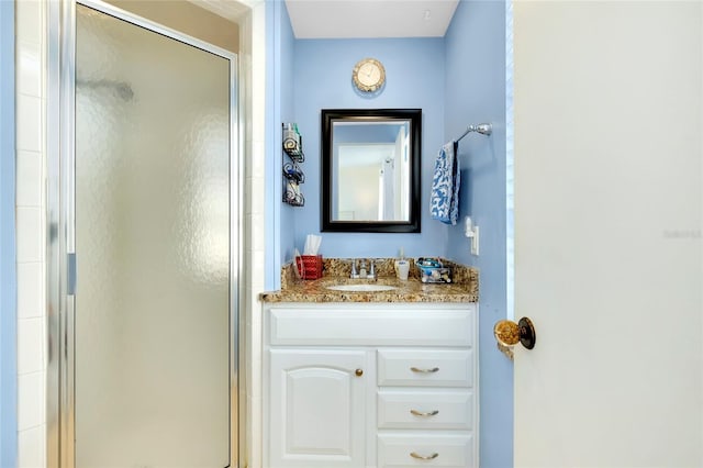 bathroom with vanity and a shower with door