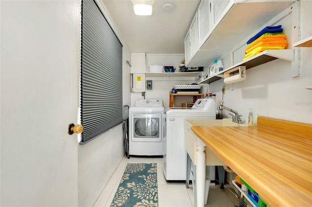 washroom featuring light tile patterned flooring, cabinets, separate washer and dryer, and electric panel