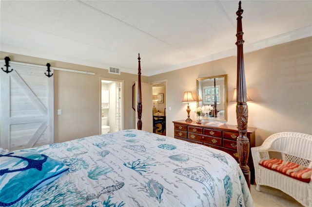 bedroom featuring a barn door, ensuite bathroom, and ornamental molding