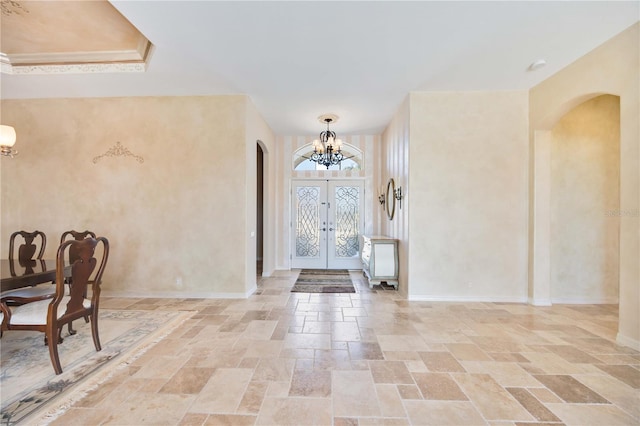 foyer featuring french doors and a chandelier