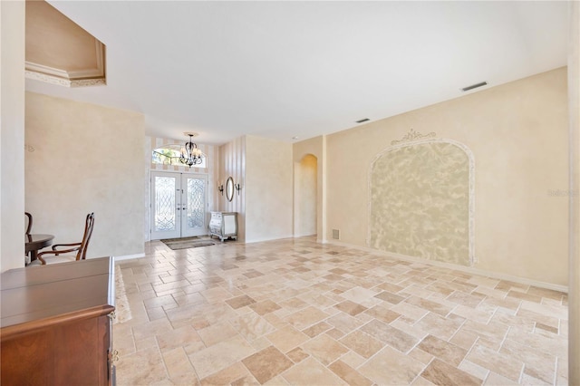 living room featuring french doors and a notable chandelier