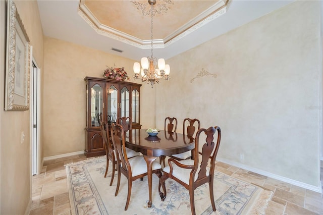 dining area with a chandelier, ornamental molding, and a tray ceiling