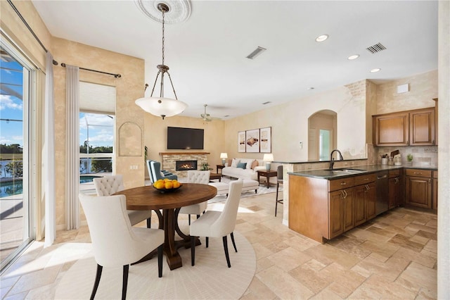 dining space featuring a stone fireplace and sink