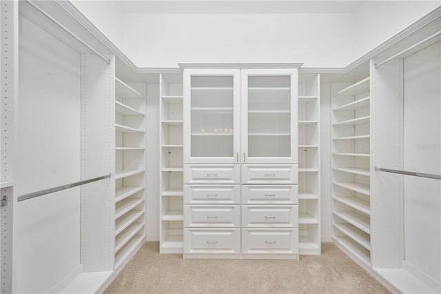 walk in closet featuring light colored carpet