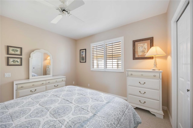 bedroom with a closet, ceiling fan, and light colored carpet