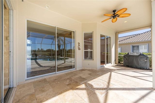 unfurnished sunroom with ceiling fan