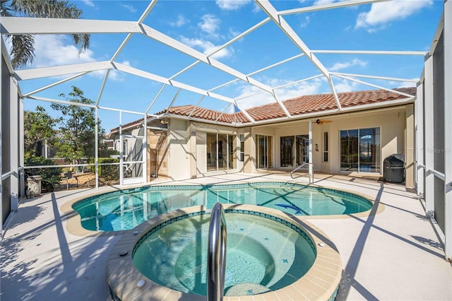 view of pool featuring an in ground hot tub, area for grilling, ceiling fan, glass enclosure, and a patio