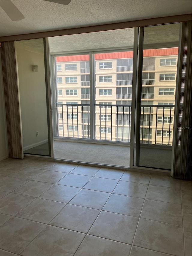 unfurnished room with a textured ceiling, ceiling fan, and a healthy amount of sunlight