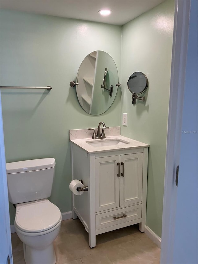 bathroom featuring tile patterned floors, vanity, and toilet