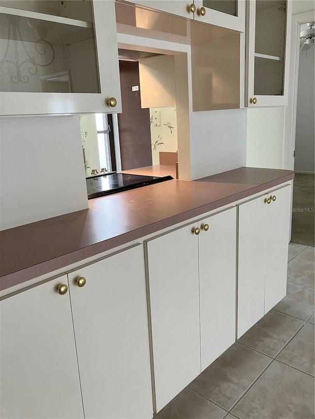 kitchen featuring white cabinetry, black electric stovetop, and light tile patterned flooring