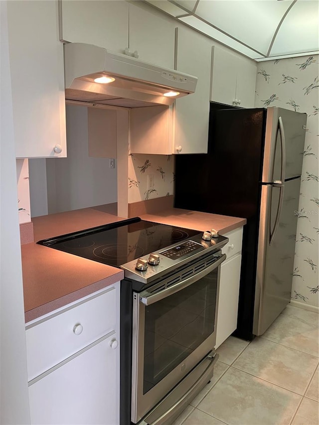 kitchen with extractor fan, stainless steel appliances, white cabinets, and light tile patterned flooring