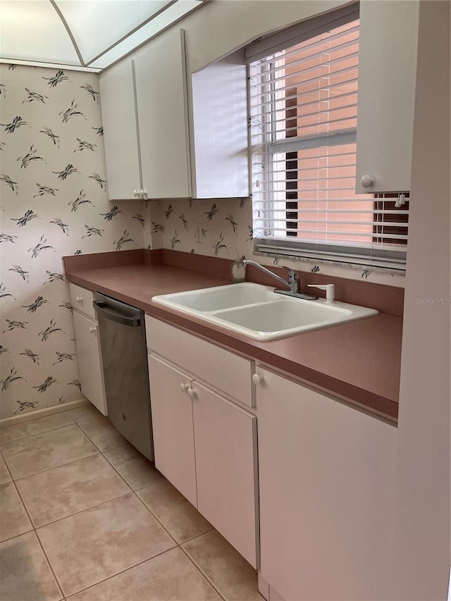 kitchen featuring white cabinetry, dishwasher, sink, and a healthy amount of sunlight