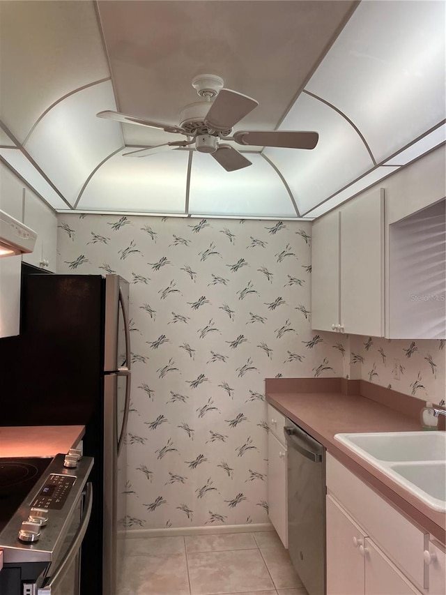 kitchen with sink, white cabinets, light tile patterned floors, ceiling fan, and stainless steel appliances