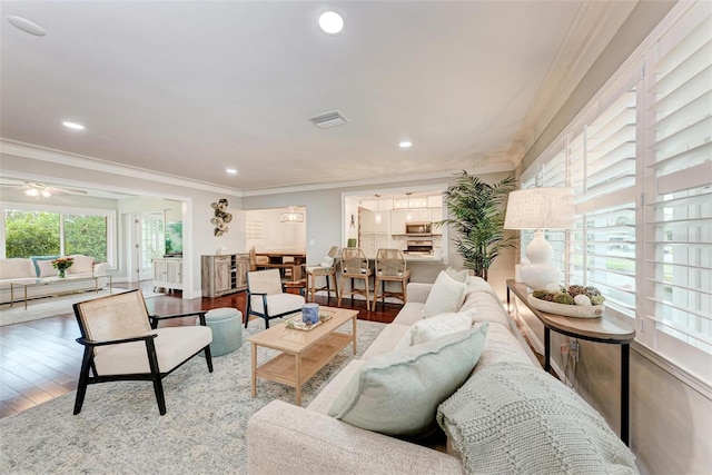 living room with ceiling fan, crown molding, and hardwood / wood-style flooring