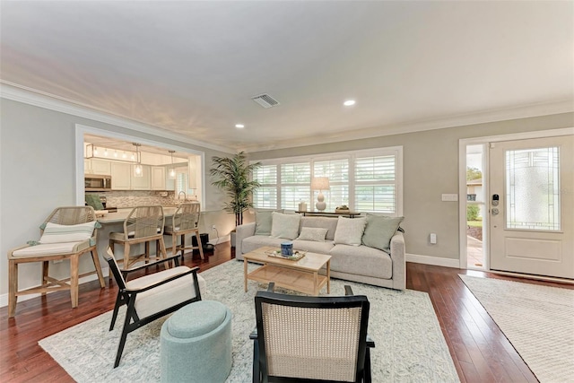 living room with dark hardwood / wood-style floors and crown molding