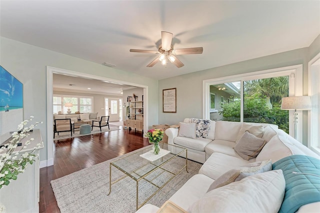 living room featuring ceiling fan and dark hardwood / wood-style flooring